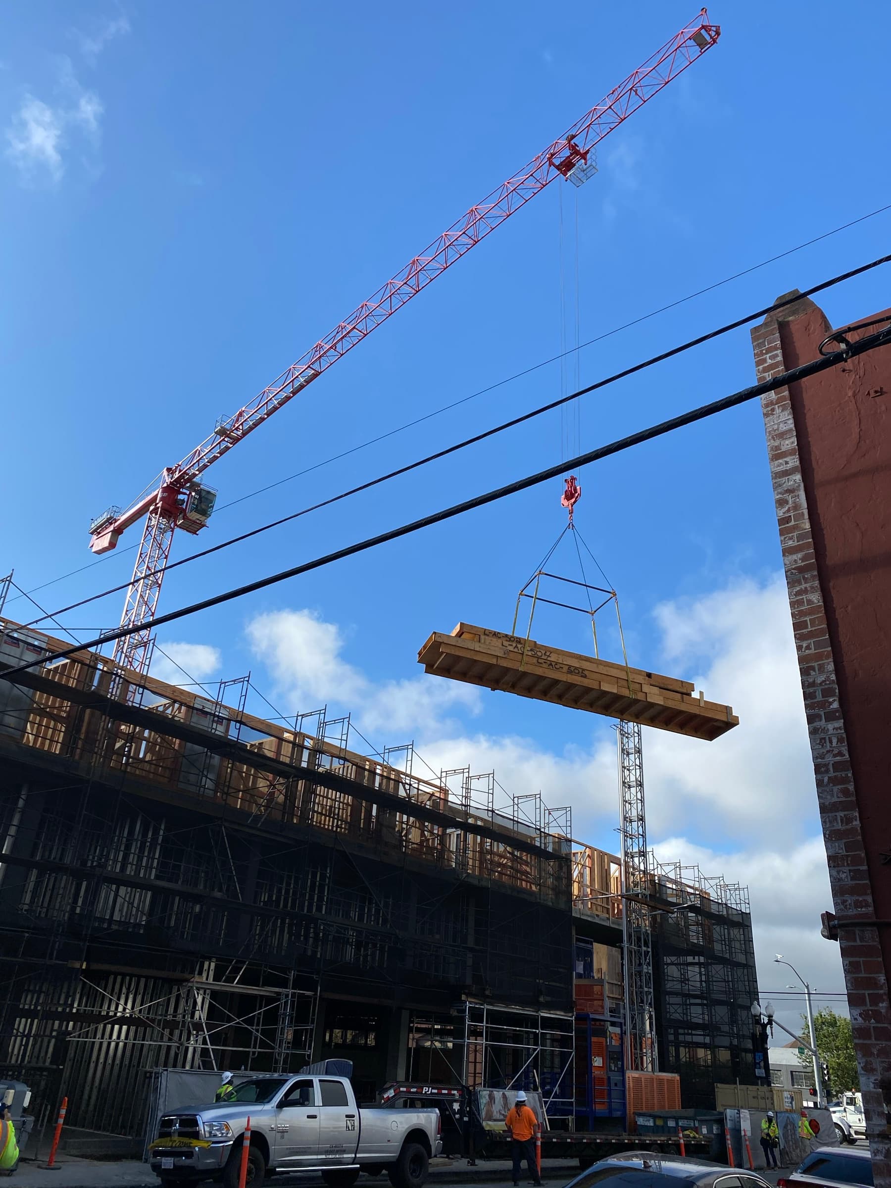 Wall panel being crane-lifted into position at 200 Linden construction site